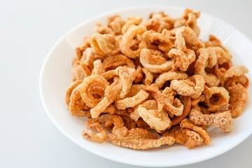 Pork rind, pork cracking,pork snack, in white plate on white background