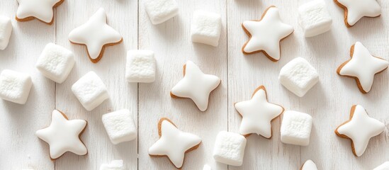 Marshmallows and gingerbread stars on white wooden background festive treat winter family theme close-up aerial view