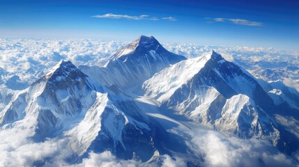 Fototapeta premium Aerial view of majestic snow-capped mountains under a clear blue sky showcasing natural beauty and grandeur in a stunning landscape.