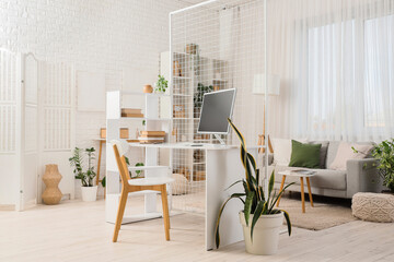 Comfortable workplace with modern computer in interior of living room