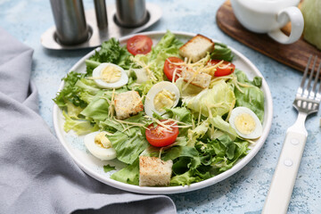 Plate with tasty Caesar salad on blue background, closeup