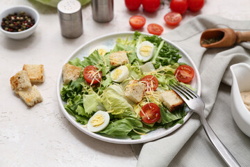Plate with tasty Caesar salad and bowl of peppercorn on white background, closeup