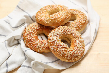 Tasty bagels with sesame seeds on wooden background, closeup