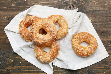 Tasty bagels with sesame seeds on wooden background