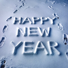 A happy new year written in the snow with footprints in the snow
