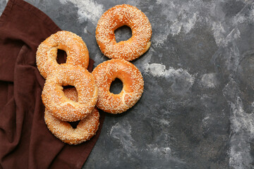 Tasty bagels with sesame seeds on black background