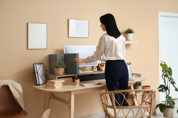 Young woman taking folder in office. Back view