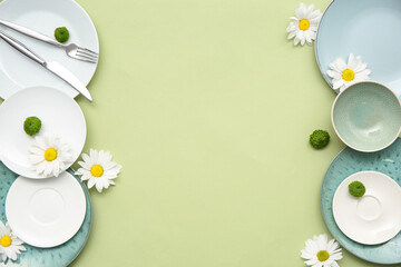 Stylish table setting with beautiful flowers on green background