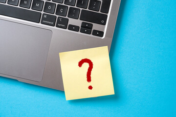 A question mark was written on a sticky note paper attached to the corner of the laptop