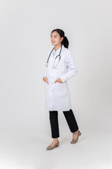 A beautiful Asian female doctor in a white gown uniform standing against a white studio background.