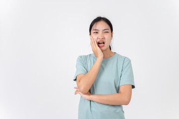 A sick, uncomfortable young Asian woman touching her cheek, suffering from a toothache.