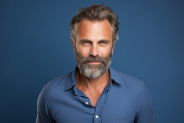 Fototapeta premium A man with a beard and a blue shirt is smiling