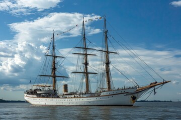 A majestic tall ship sailing on calm waters under clouds.