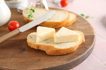 Wooden board of bread slice with triangles of tasty processed cheese on pink tile background