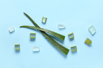 Composition with whole and cut fresh aloe leaves on color background