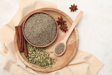 Wooden plate with different spices and spoon on light background