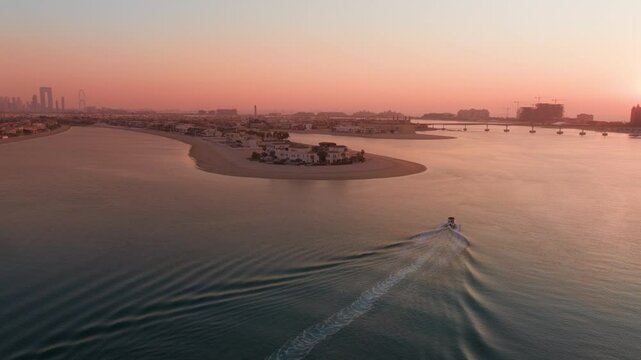 The breathtaking aerial view of Palm Jumeirah in the UAE, captured beautifully at sunset, showcases its iconic palm treelike shape and the stunning skyline that surrounds it