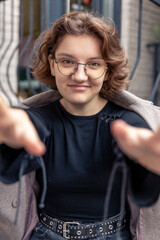 Happy girl stretches her hands to the camera. Emotion concept.