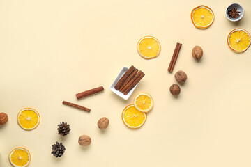 Composition with cinnamon sticks, walnuts, dried orange slices and pine cones on color background