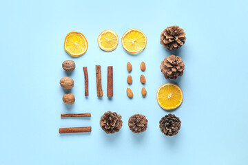 Composition with cinnamon sticks, nuts, dried orange slices and pine cones on color background