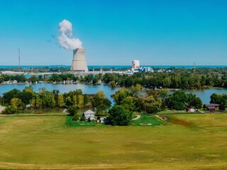 High-angle view of a nuclear power plant on a lake, with surrounding residential areas and...