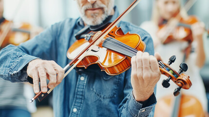 Fototapeta premium Close up professional Caucasian musician elderly man playing the violin with symphony orchestra classical music on violin. Talented violinist and classical music player solo performance