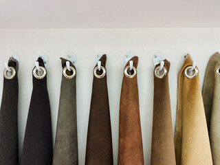 A neatly arranged row of soft, luxurious brown towels hangs gracefully on strong, sturdy wall hooks, contributing to a warm and inviting ambiance in a bathroom or tranquil spa setting
