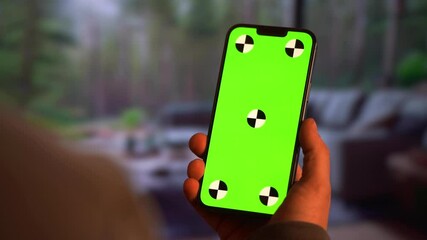 Young person using vertical smartphone. Green screen
