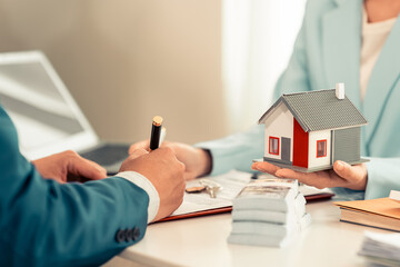 Real estate agents offer home models to clients who hold commercial real estate contract forms and...