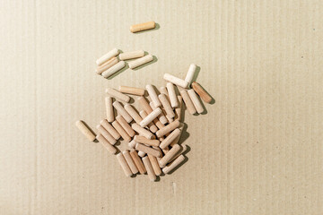 Wooden dowels for furniture assembly lie on a cardboard surface. Furniture dowels close-up.