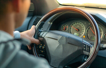 Driving with a car . View from car inside. Steering wheel with man hand
