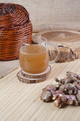 red ginger brewed drink photographed in a studio setting with traditional Indonesian theme props