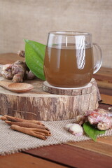 red ginger brewed drink photographed in a studio setting with traditional Indonesian theme props