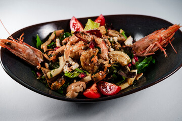 mixed salad with grilled seafood : shrimps, calamari, prawns as perfect healthy  balanced food for mediterranean diet on white background