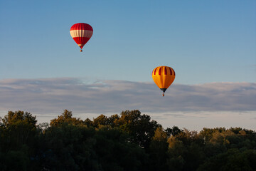 Naklejka premium Striped Hot Air Balloons Above a Forest Canopy