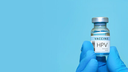 A doctor holds a vial of the HPV vaccine. Experimental HIV vaccine vial for immunization against...