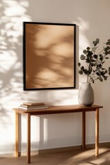 Modern interior design with empty frame, plant, and books on wooden table