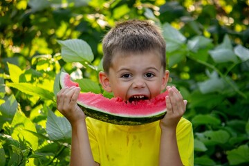 The child eats watermelon in the summer. Selective focus