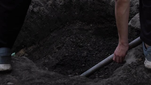 someone unknown person is digging me a dark black and white scary video. The concept of solving crimes and evidence, crime, hostage