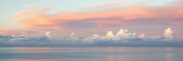 Obraz premium Serene Seascape with Soft Pastel Clouds Reflecting on Calm Water During Sunrise, Creating a Tranquil and Peaceful Atmosphere for Nature Lovers and Photographers