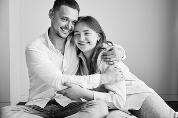 Portrait of father and teenage daughter hugging each other at home. Cute moment of dad and child in glasses showing their love to each other. Lovely spending time with family. Black and white image.