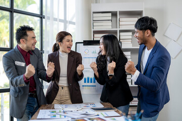 A group of people are celebrating a success in a business meeting