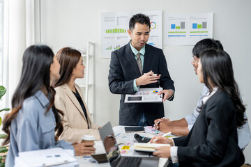 The man is holding a presentation and the group of people are looking at him