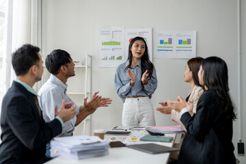 A woman is standing in front of a group of people, giving a presentation