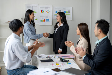 A group of people are shaking hands in a business setting