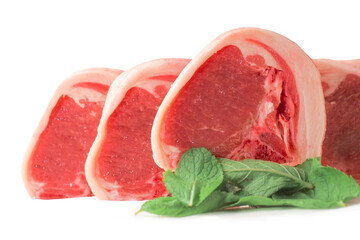 Fresh uncooked lamb loin chops and mint leaf on white background. High quality meat product cut by butcher in perfect size for cooking. Food supply chain and agriculture industry.
