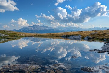Stunning landscape featuring a tranquil alpine lake mirroring a majestic mountain range under a vibrant sky dotted with fluffy clouds