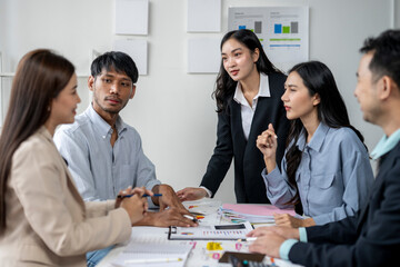 A group of people are sitting around a table, some of them are wearing suits