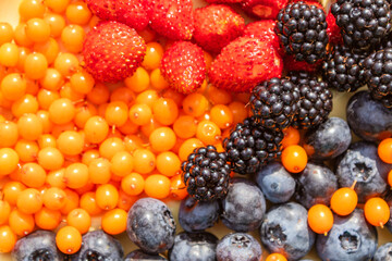 Mixed various berries collected on the plot, assorted berries of blackberries, strawberries, blueberries, sea buckthorn. Colorful and healthy concept. Black, blue, red, green. close up