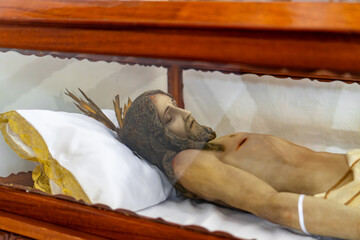 A man is lying on a bed with a cross on his head